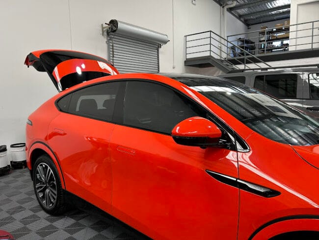 Tesla Model Y tinted with premium film – standout red EV with glare reduction and cabin heat control.