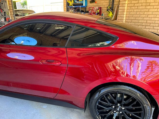 Glossy red sports coupe with sleek window tint – enhances style, reduces glare, and protects interior from UV damage.